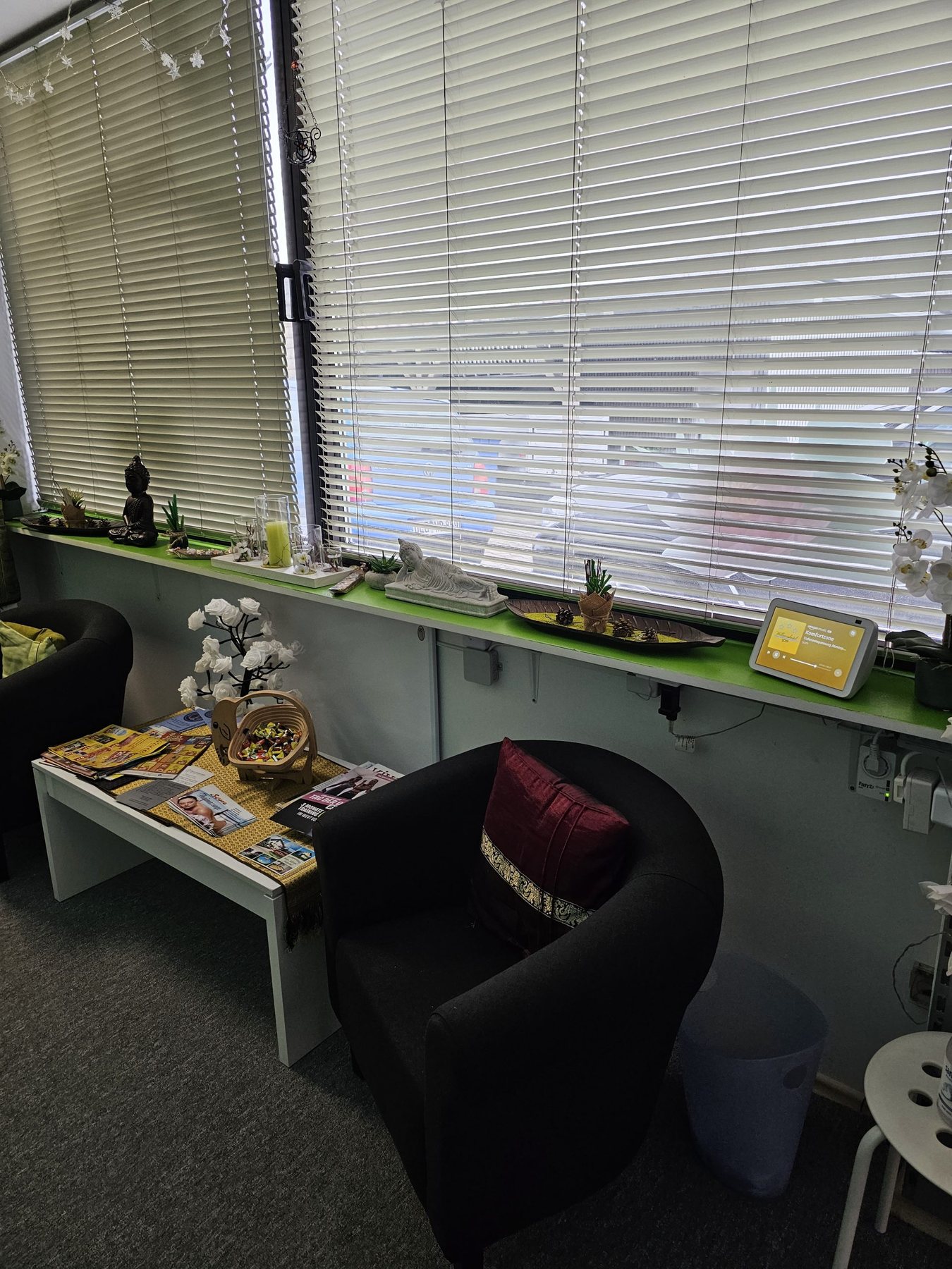 Empfangsbereich des Som-Studios mit Buddha und Blumen